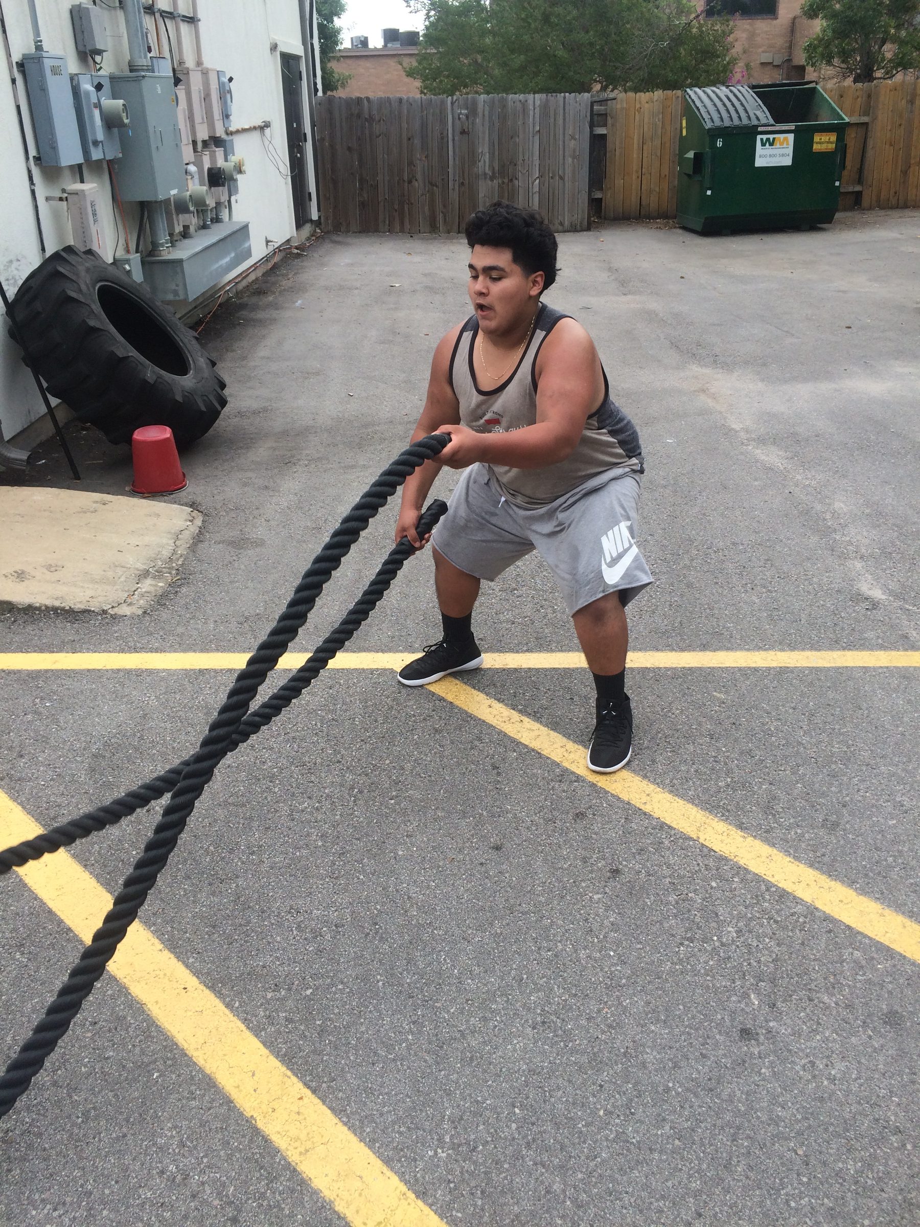 PowerHouseATX client using battle ropes outside the gym